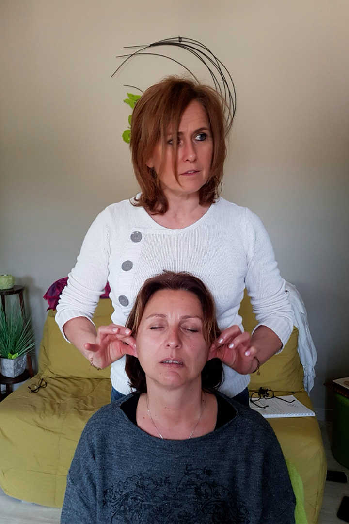 Formatrice en réflexologie crânienne transmettant le protocole du soin crânien lors d’une formation en petit groupe.